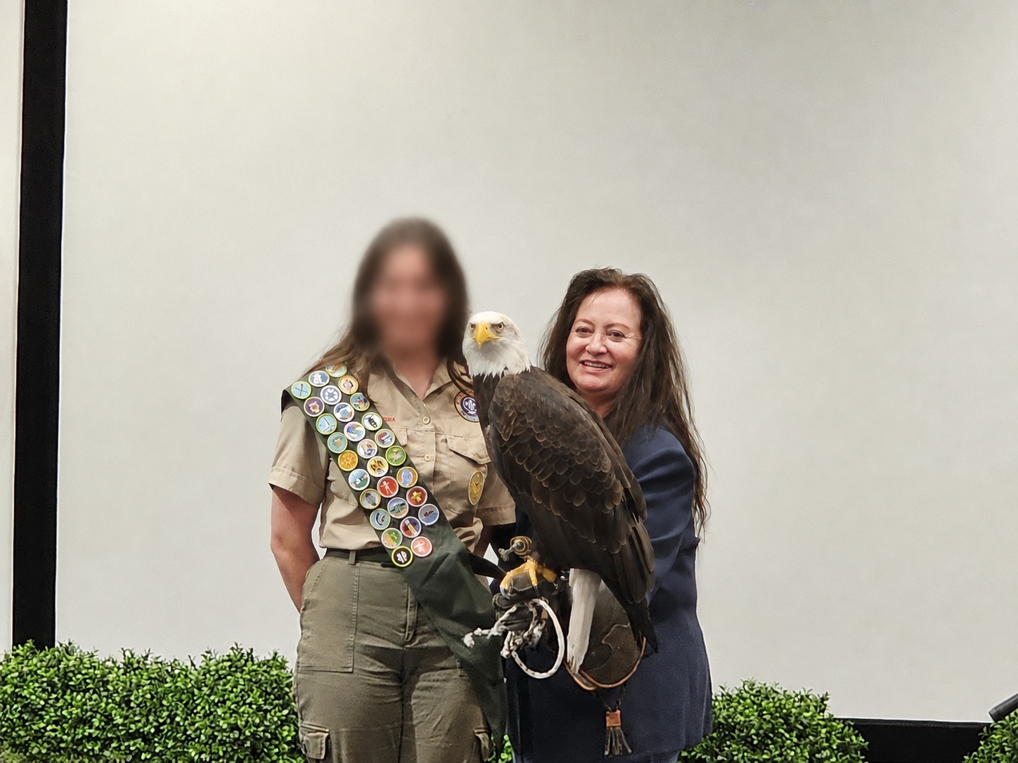 primary caretaker and a scout with a Bald Eagle following a conservation-education program